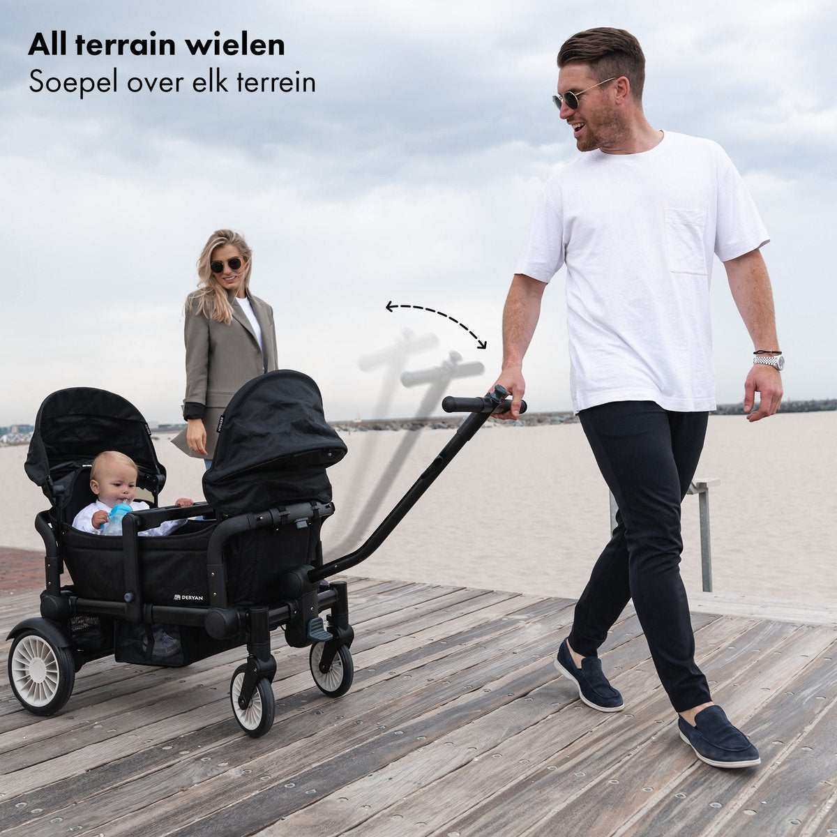 El carrito DERYAN en negro es un carrito plegable que se puede utilizar para transportar niños y objetos. El modelo tiene un chasis robusto, cuatro ruedas y un diseño plegable. El carrito es adecuado para su uso durante excursiones y al aire libre.