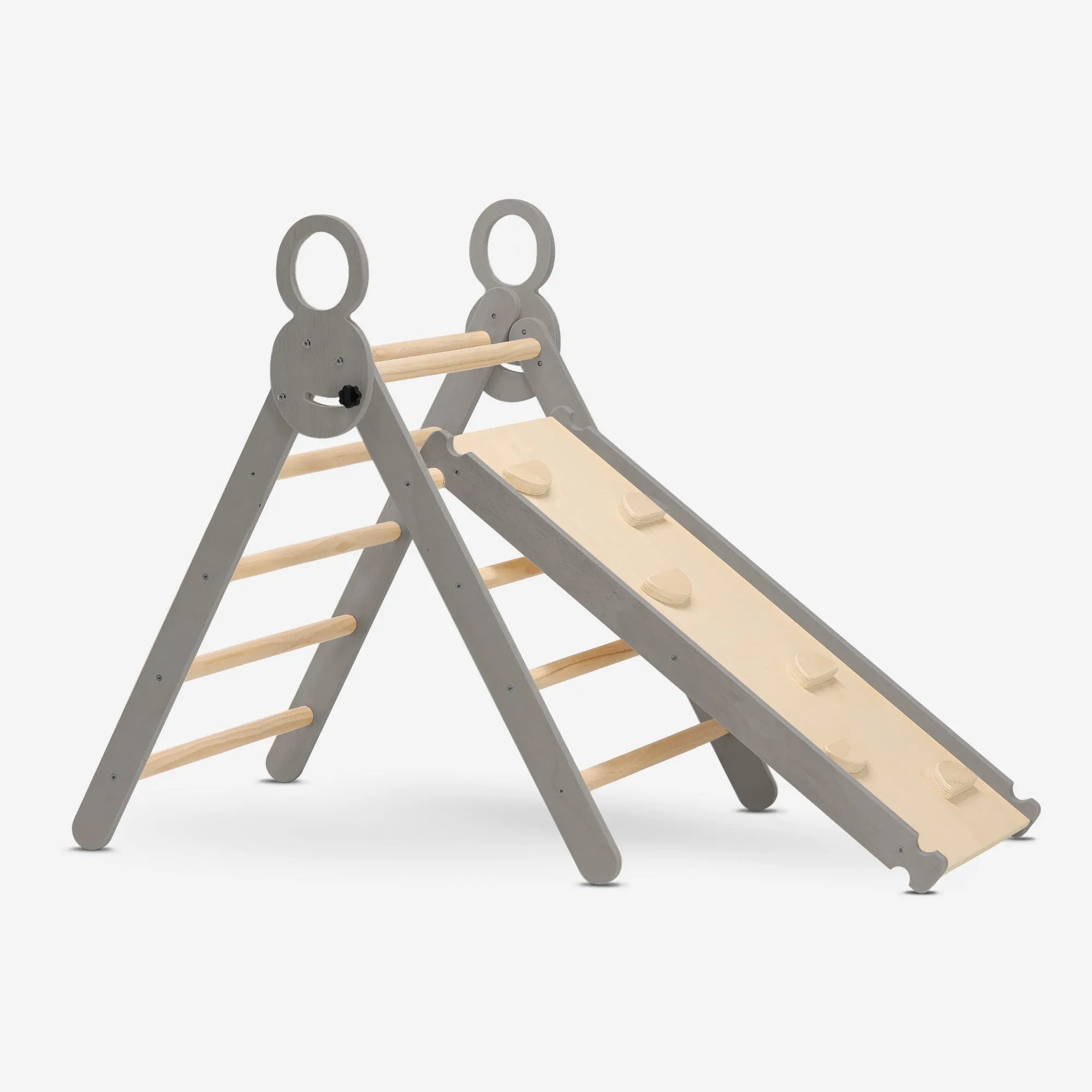 The DERYAN wooden climbing frame in gray consists of a foldable triangle with a climbing arch and a ramp with slide. The climbing frame is made of wood and intended for indoor use by young children during play and exercise.