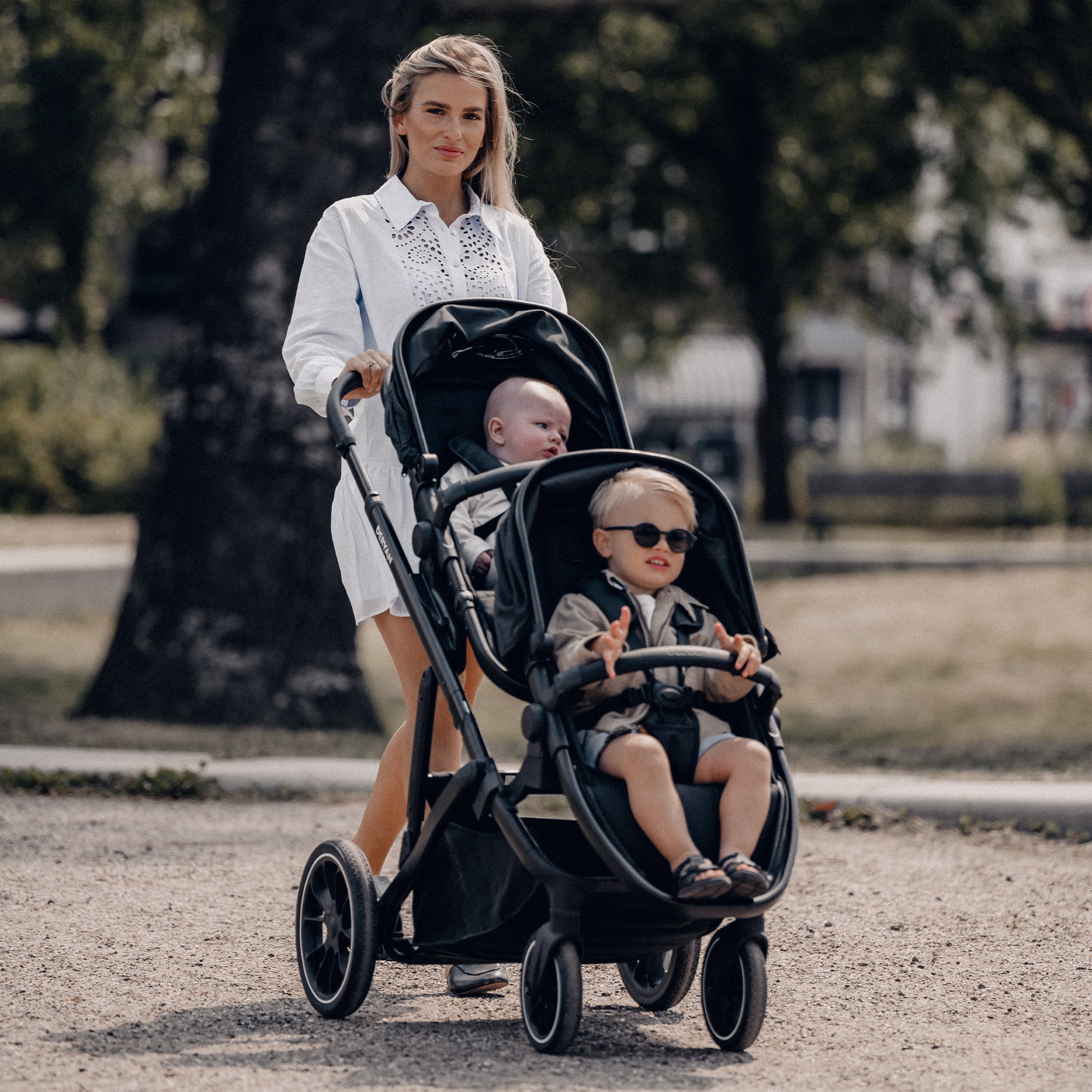 DERYAN EVY V2 Duo Pram i sort har to sæder og et design, der kan klappes sammen med én hånd. Modellen har justerbare sæder og en fodstøtte, en solskærm med SPF 50 plus, et affjedringssystem og en fempunktssele til begge siddepladser.