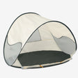 Cream Compact Beach Tent, cream-colored with an open entrance, on a sandy beach