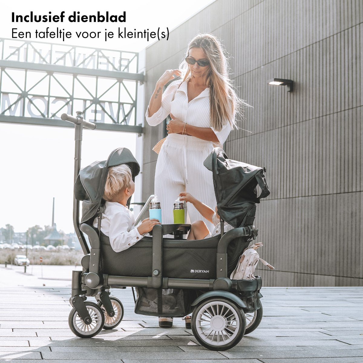 The DERYAN wagon in black is a foldable cart that can be used to transport children and belongings. The model has a sturdy frame, four wheels, and a foldable design. The wagon is suitable for use during outings and outdoors.