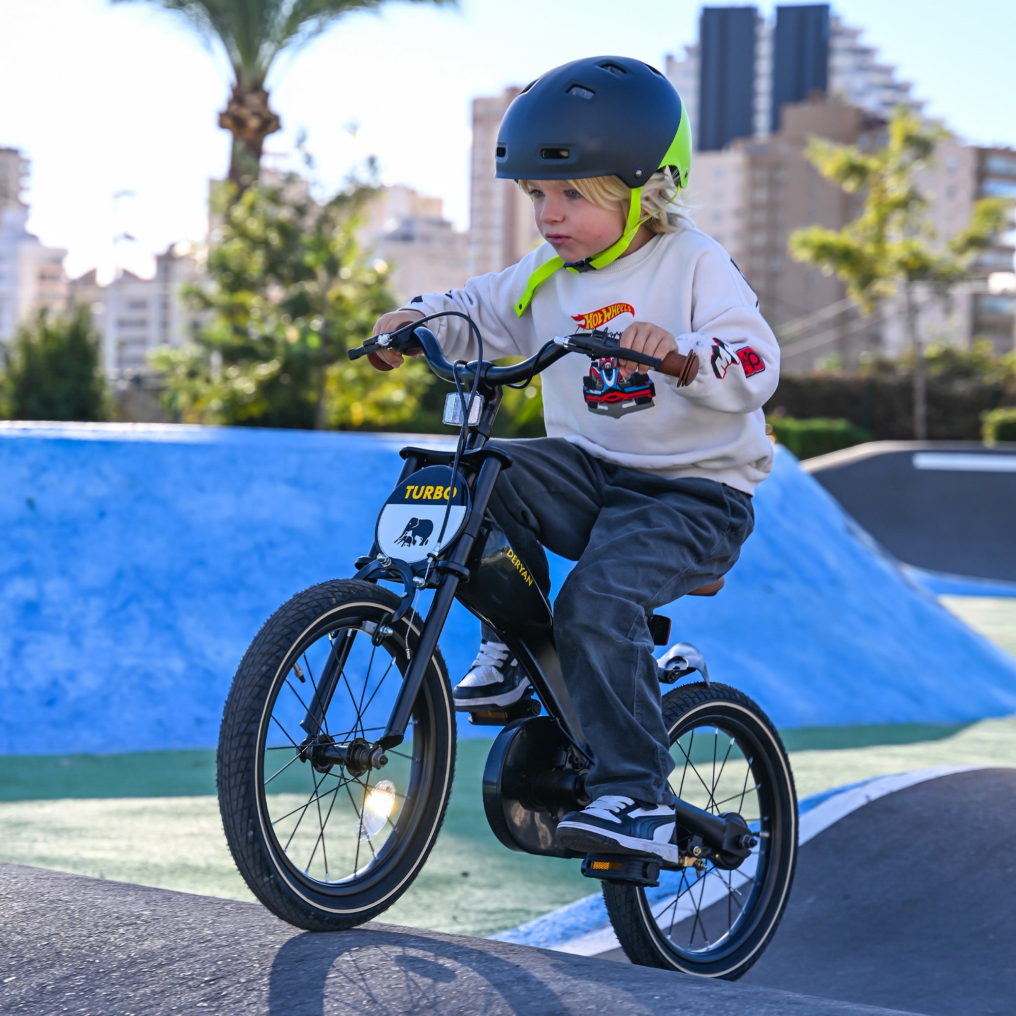 The DERYAN 14-inch children's bike can be used as a balance bike, training bike, and children's bike. The model has adjustable handlebars, a PU leather saddle, removable pedals, and a closed chain guard. The bike is designed for children who are learning to ride.