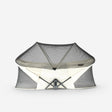 The Infant Deluxe BabyBox Travel Crib in Cream, with a lightweight aluminum frame, sets up in 2 seconds